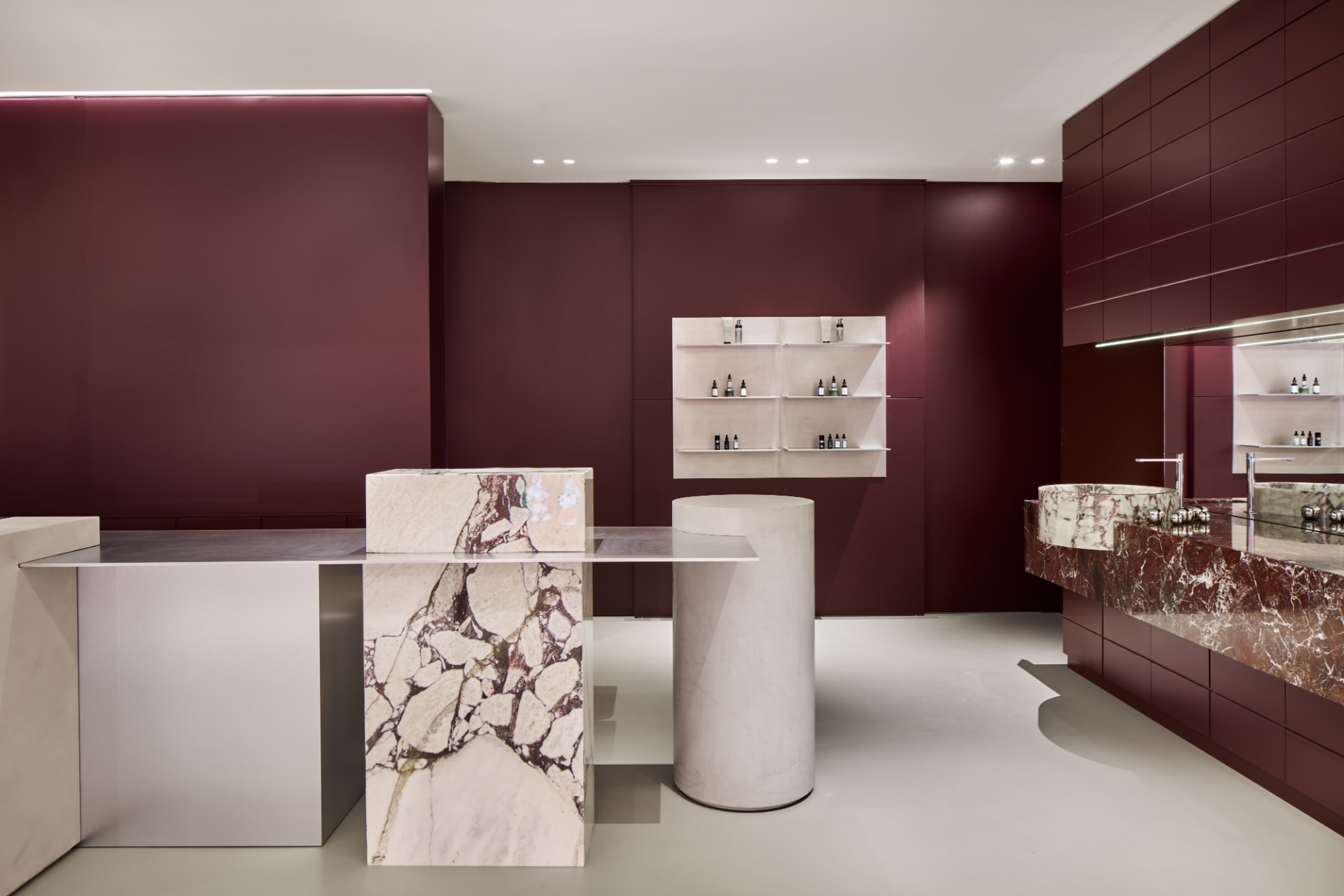 Empfangsbereich mit Marmortresen und Oxblood-Wänden